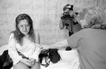 "Safer Cities" reported on whether women are more at risk of violence. Here a police officer photographs Barbie Robinson as nurse Suzanne Flandrick exposes Robinson's arm, scratched and bruised when her boyfriend threw her against a car after an argument. Photo: Ginger Pinson/Pioneer Press