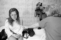 "Safer Cities" reported on whether women are more at risk of violence. Here a police officer photographs Barbie Robinson as nurse Suzanne Flandrick exposes Robinson's arm, scratched and bruised when her boyfriend threw her against a car after an argument. Photo: Ginger Pinson/Pioneer Press