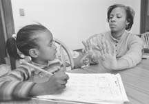 Delia Morehead's struggle to overcome fourth generation poverty, single motherhood and joblessness was one of the stories told in "Poverty Among Us." Here, the 28-year-old helps one of her six children do homework. Photo: Joe Rossi/Pioneer Press